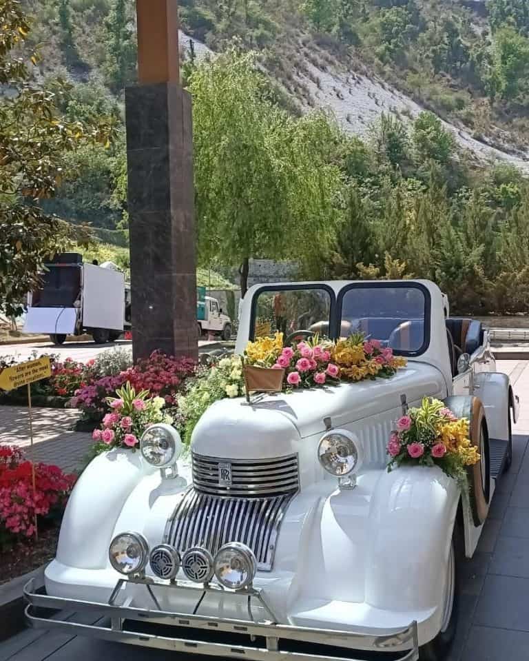 A decorated white vintage car in the laps of mussoorie hills