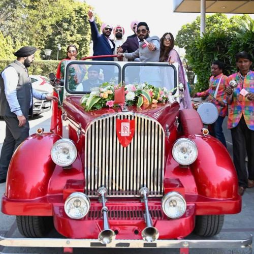 Groom on a red vintage car for wedding dancing